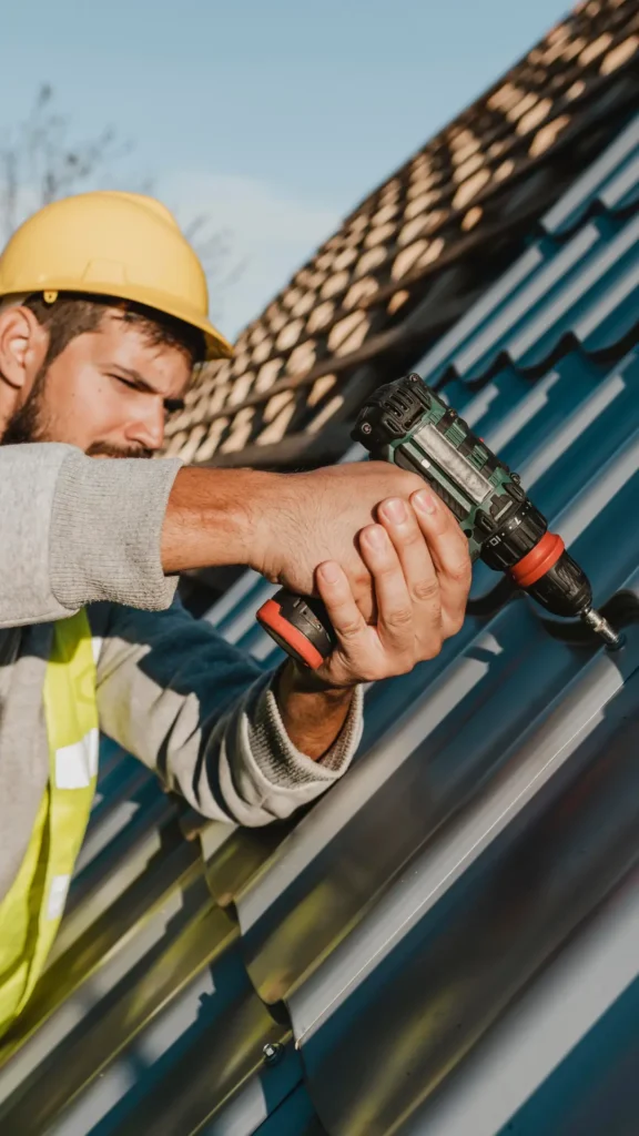 man-fixing-a-metal-roof-on-a-house-576x1024